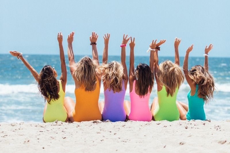 Girls posing in different color bathing suits 