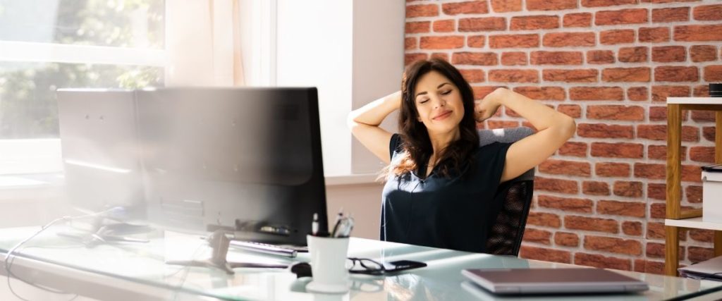 Woman Stretching at desk_Office Wellness Guide: 5 Ways to Maintain a Healthy Body and Mind